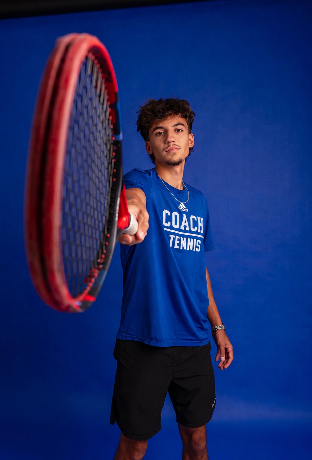 Alexis, raquette à la main, sur fond bleu